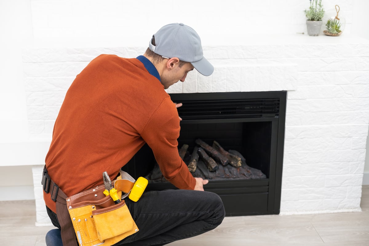 Man cleaning fireplace from ashes.